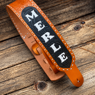 Merle Haggard hand-tooled leather guitar strap with black floral tooling and white lettering